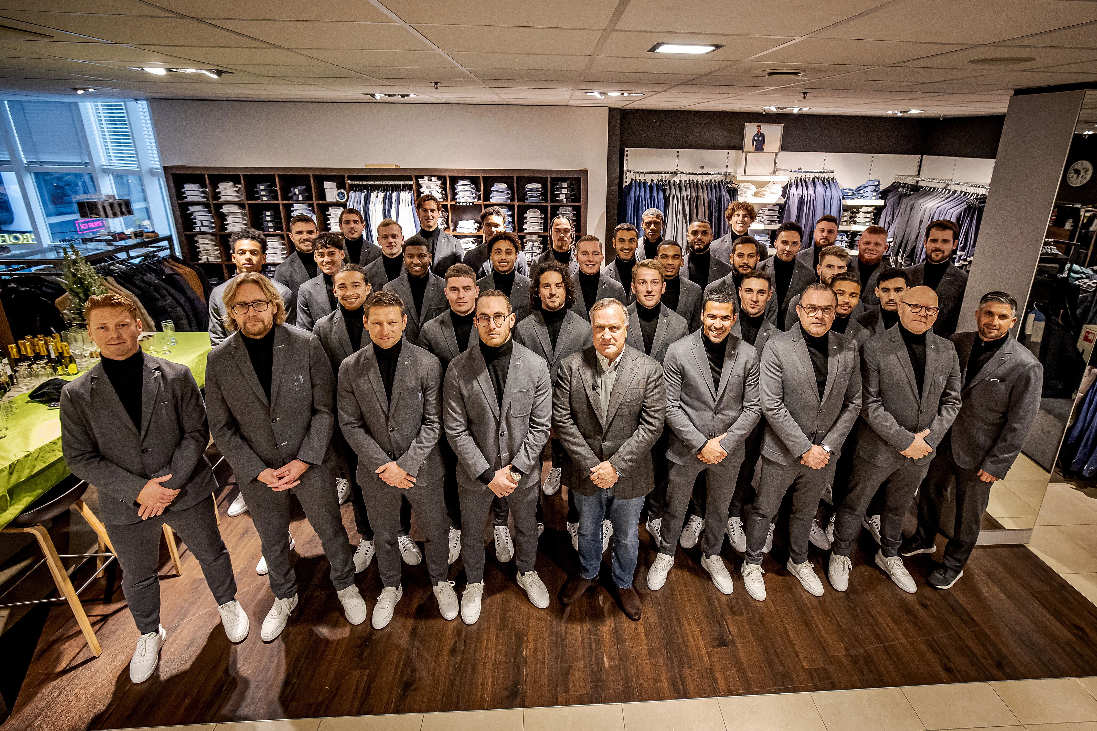 Teamfoto Ado Den Haag heren poserend in pakken bij Van Uffelen Mode Zoetermeer