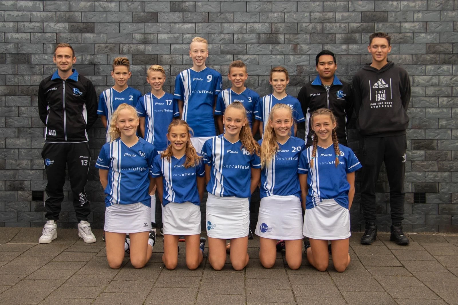 Teamfoto van korfbalvereniging Avanti Pijnacker poserend tegen een muur