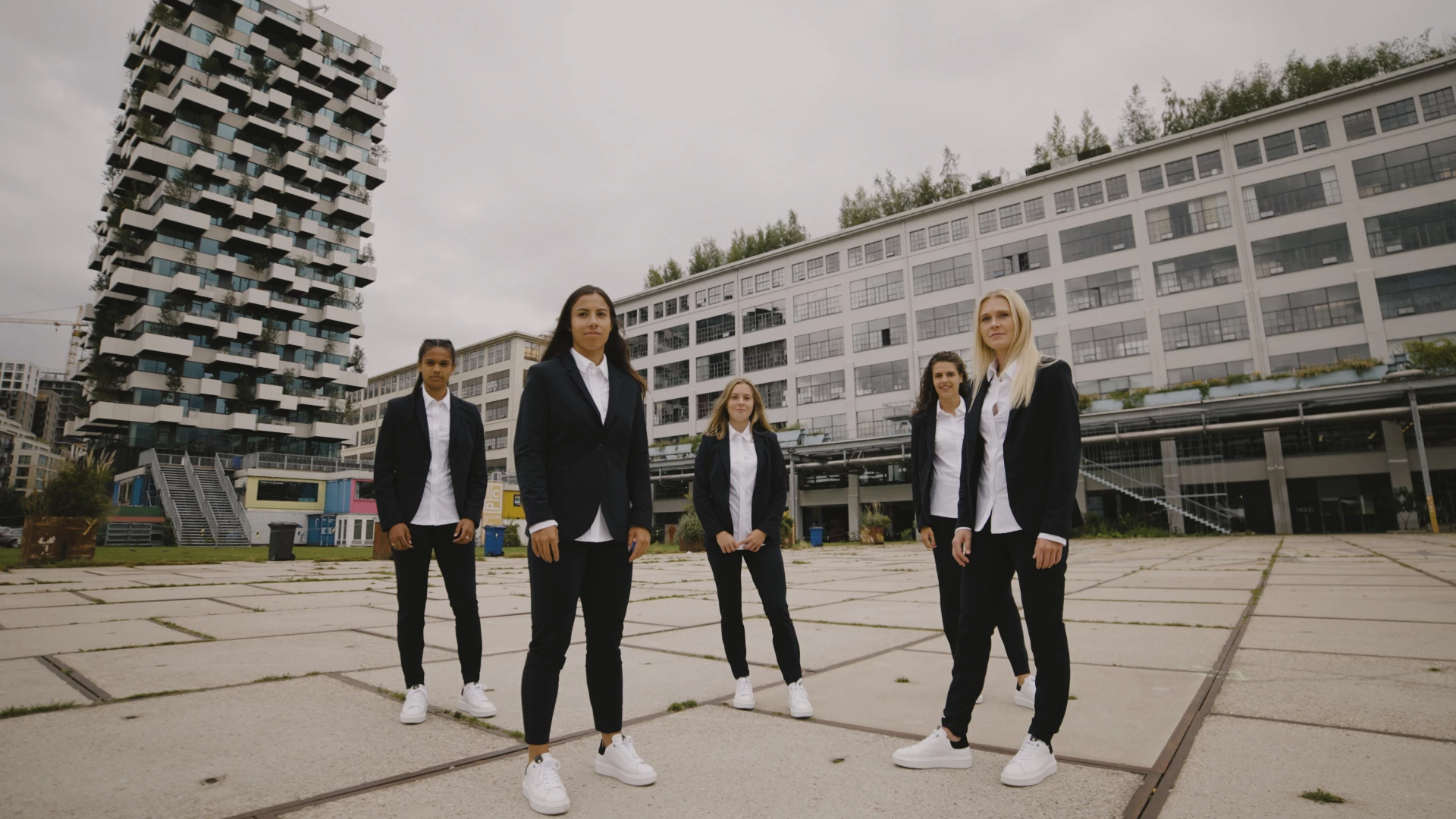 PSV dames team gekleed in kleding van Expresso op een achtergrond van gebouwen en flats